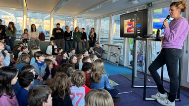 Lesung einer Autorin mit Mikrofon auf dem Bücherschiff vor Kinderpublikum