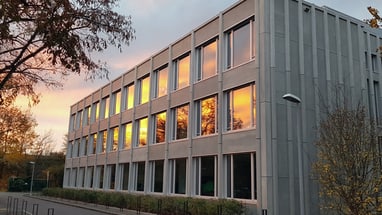 Gebäude mit Fenstern, Sonnenuntergang spiegelt sich wider.