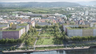 Luftbild von Stadt mit grünem Park und Flussufer.