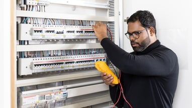 Elektriker arbeitet an einem Schaltschrank.