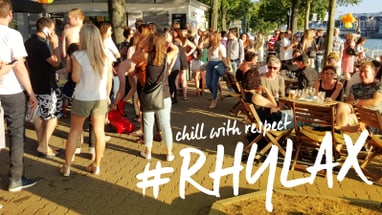 Menschenmenge draussen bei sonnigem Wetter mit 'chill with respect #RHY LAX' Schriftzug.