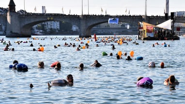 Viele Menschen, die an einem schönen Sommertag im Rhein baden.