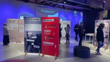 Ausstellung über Rassismus und Identität mit Informationstafeln und Besuchern.