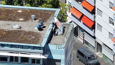 Eine Person auf einem flachen Dach in einer Stadtumgebung.
