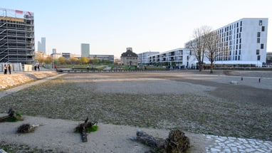 Baustelle mit modernen Gebäuden im Hintergrund.
