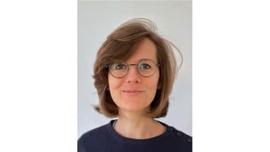 Person mit Brille vor neutralem Hintergrund.