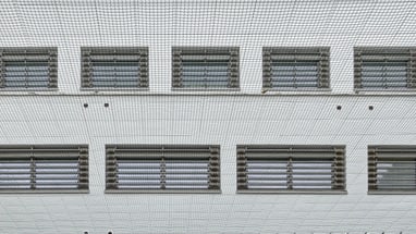 Gebäudeansicht durch ein Gitter.