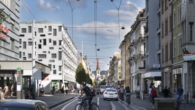 Strassenszene mit Radfahrern und Autos im Gundeli.