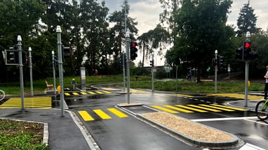 Übungsverkehrsfläche mit Ampeln und Zebrastreifen vor Bäumen.