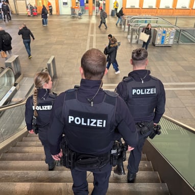 Polizisten gehen Treppe in Bahnhof hinunter.