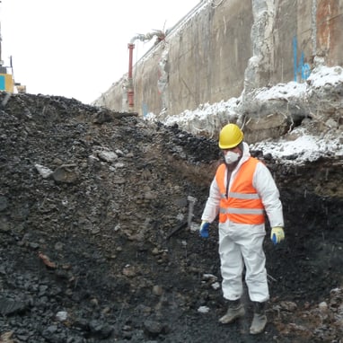 Arbeiter in Schutzkleidung an einer Baustelle mit Aushub.