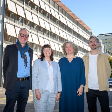 Projektverantwortliche stehen vor dem modernen Gebäude an der Hochbergerstrasse 158 in Basel