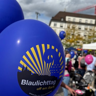 Blaue Blaulichttag-Ballone auf belebtem Barfüsserplatz am 13. September 2025