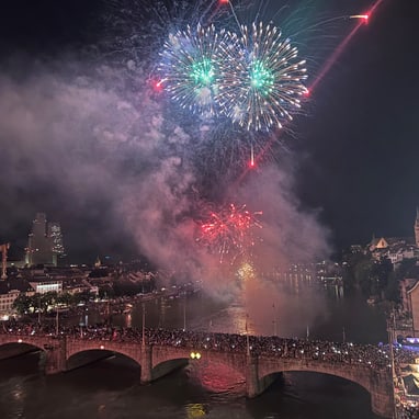 Feuerwerk über einer belebten Brücke in einer Stadt bei Nacht.
