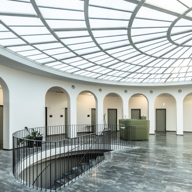 Moderner grosser Raum mit Glasdach und Wendeltreppe.