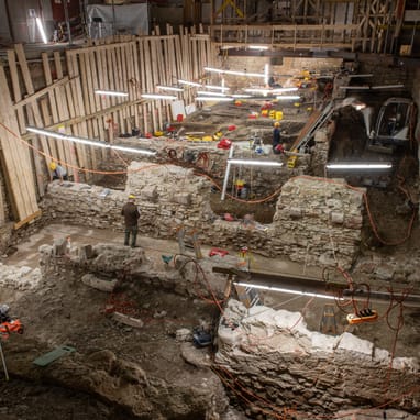 Archäologische Ausgrabungsstätte mit Bauarbeiten und Beleuchtung.