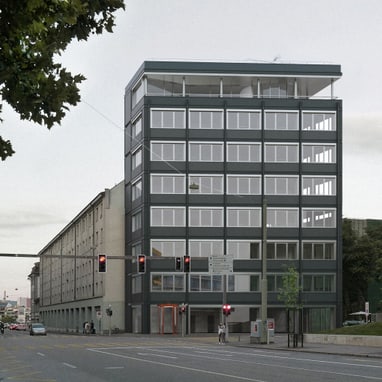 Strassenszene mit modernem Gebäude und Bäumen bei einer Kreuzung.