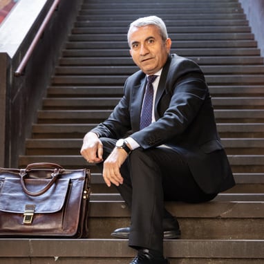 Mustafa Atici auf Treppe mit Aktentasche.