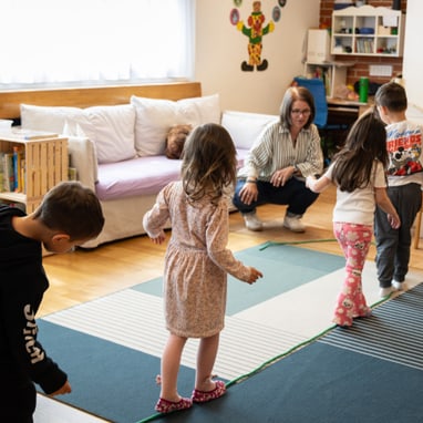 Kinder spielen auf dem Boden in der Spielgruppe.
