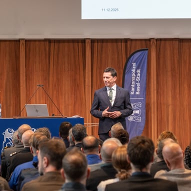 Mann hält Vortrag vor Publikum in einem Saal.
