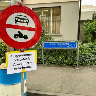 Verbotsschild für Autos und Motorräder mit Ausnahmehinweis an Strasse 'In den Ziegelhöfen'.