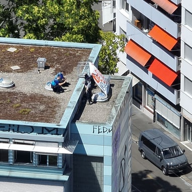 Eine Person auf einem flachen Dach in einer Stadtumgebung.