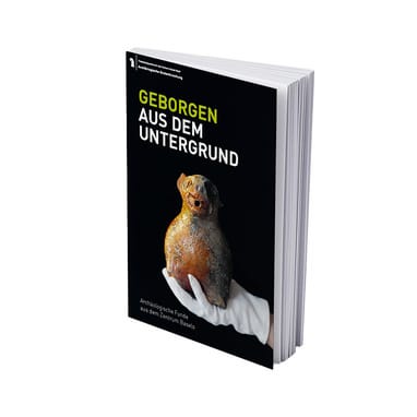 Buchcover mit Hand mit weissem Handschuh die ein mittelalterliches Wassergefäss fürs Händewaschen (Aquamanile) hält. Der Titel lautet: "Geborgen aus dem Untergrund: Archäologische Funde aus dem Zentrum Basels"
