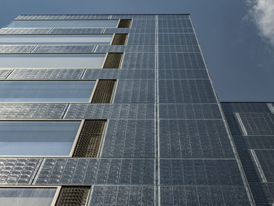 Ansicht eines modernen Gebäudes mit Solarmodulfassade gegen den Himmel.