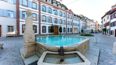 Historische Altstadt mit Brunnen und Kopfsteinpflasterstrasse.
