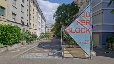 Strasse mit bepflanztem Absperrung und 'Superblock' Schild.