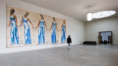 Person geht durch eine Galerie mit Gemälde an der Wand.