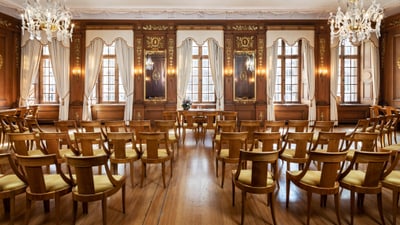 Blick in einen grossen antiken und edlen Saal mit Holzstühlen und Kronleuchtern