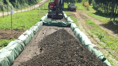 Bagger umgeben von Sandsäcken.