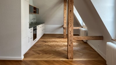 Moderne Dachgeschosswohnung mit Holzbalken.",