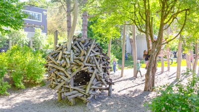 Grosse Holzskulptur in einem sonnigen Park.