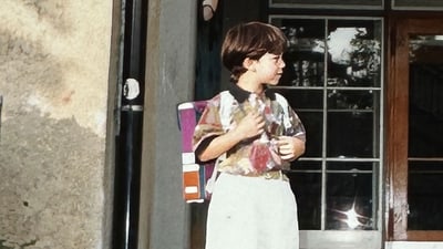 Manuel Ballarino mit Rucksack vor Tür stehend.",