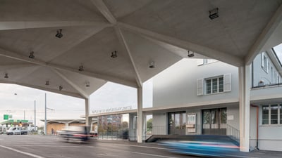 Zollgebäude davor die Überdachte Strasse auf der zwei Autos fahren.