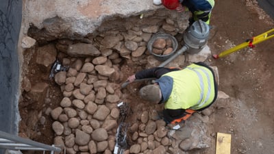 Archäologen bei der Ausgrabung einer antiken Mauer.