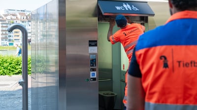 Arbeiter warten eine öffentliche Toilette.