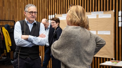 Urs Bucher und sein Leitungsteam diskutieren vor einer Pinnwand in einem Seminarraum.