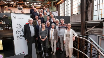 Gruppe von Menschen auf Treppe in Loft-Umgebung bei Tageslicht.
