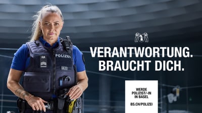 Polizistin in Uniform vor unscharfem Hintergrund mit Schriftzug.