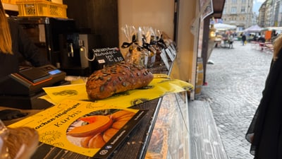 Brotlaib in einer Bäckerei mit gepflasterter Strasse im Hintergrund.