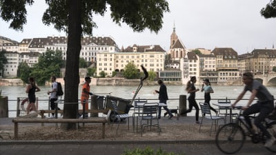 Fussgänger und Radfahrer vor dem Rhein in Basel.