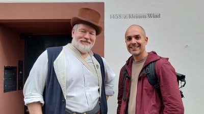 Zwei Männer stehen vor einem Gebäude.