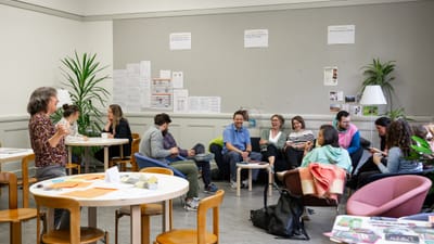 Das Kollegium vom Isaak Iselin in einem Gemeinschaftsraum sitzend und diskutierend.
