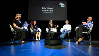Diskussionsrunde mit fünf Personen auf der Bühne.