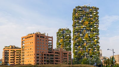 Moderne Hochhäuser mit vertikalen Gärten neben traditionellen Gebäuden.