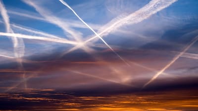 Kondensstreifen am farbenfrohen Himmel bei Sonnenuntergang.