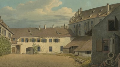 Hof mit historischen Gebäuden und bewölktem Himmel.